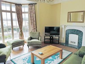 a living room with a fireplace and a tv at The Captains House in Instow