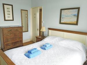 a bedroom with a bed with two towels on it at The Captains House in Instow +8 photos