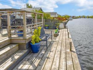 a wooden dock with benches and plants on the water at Evening Glory in Brundall