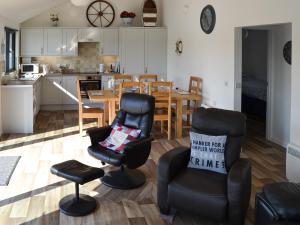 a kitchen and living room with chairs and a table at Evening Glory in Brundall