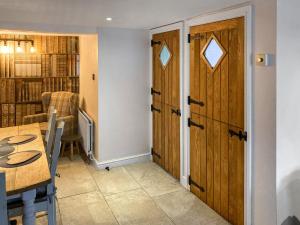 a room with a table and a wooden door at Cosy Cottage in Portinscale