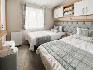a small room with two beds and a window at Sandy Shore - Uk37724 in Ingoldmells