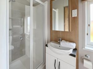 a bathroom with a white sink and a shower at Sandy Shore - Uk37724 in Ingoldmells