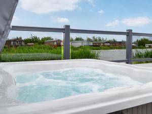 a jacuzzi tub on the deck of a house at Sandy Shore - Uk37724 in Ingoldmells +2 photos