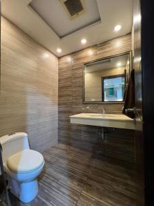 a bathroom with a toilet and a sink and a mirror at Serene Comfort Suites in Rawalpindi