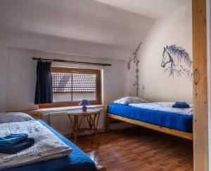 a bedroom with two beds and a horse picture on the wall at Ranč Červený mlýn in Lisov