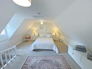 a bedroom with a white bed in a attic at Rectory Cottage in Isham