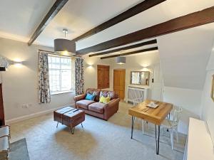 a living room with a couch and a table at Rectory Cottage in Isham