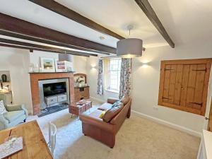 a living room with a couch and a fireplace at Rectory Cottage in Isham