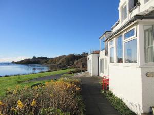 a white house with a view of the water at South Bay Cottage in Saasaig