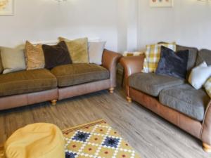 a living room with two couches and a rug at The Farmhouse - Uk50909 in Thornhaugh