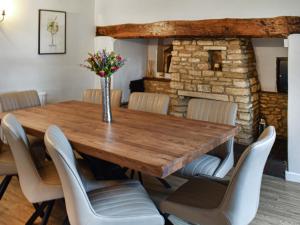 a dining room with a wooden table and chairs at The Farmhouse - Uk50909 in Thornhaugh