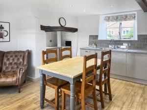 a kitchen with a table and chairs in a room at The Farmhouse - Uk50909 in Thornhaugh