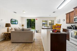 a kitchen and living room with a couch and a table at Family Friendly - South Facing Pool - Game Room - Gated - Near Disney in Davenport