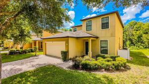 a yellow house with a garage at Family Friendly - South Facing Pool - Game Room - Gated - Near Disney in Davenport