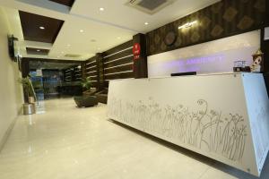 a lobby with a wall with drawings of flowers on it at Hotel Ambience in Jhānsi