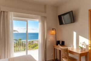 ein Schlafzimmer mit Schreibtisch und Meerblick in der Unterkunft Mareta View - Boutique Bed & Breakfast in Sagres