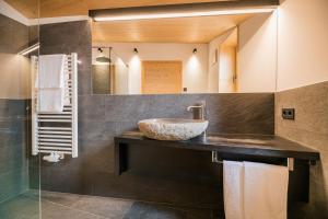 a bathroom with a sink and a mirror at Rotwandwiesen Chalets SKI IN/OUT - 1900mt in Sesto +44 photos