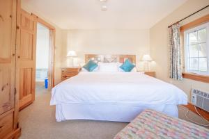 a bedroom with a large white bed with blue pillows at 136 Birdie Simcoe Cottage private Beach, Kayak in Georgina