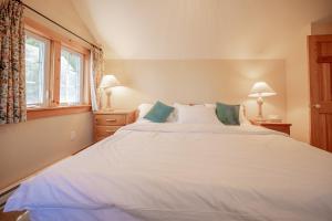 a large white bed in a room with a window at 136 Birdie Simcoe Cottage private Beach, Kayak in Georgina +33 photos