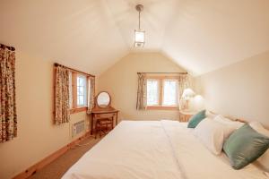 a bedroom with a large white bed in a attic at 136 Birdie Simcoe Cottage private Beach, Kayak in Georgina