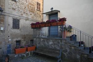 a building with a bench and a balcony with flowers at Palazzo NiTe in Bagnoregio