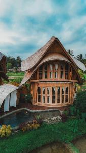 a large wooden house with a roof at Green Lander Ubud in Ubud +42 photos
