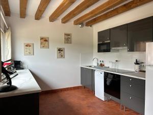 a kitchen with black and white cabinets and a sink at La Bernache Solognote in Viglain