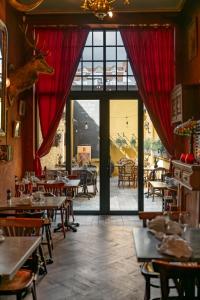 a restaurant with tables and chairs and a large window at Gran Hotel De Passage in Bruges