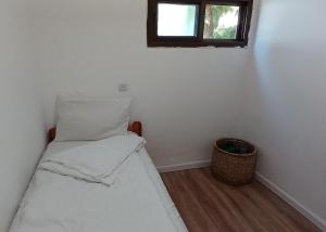 a small room with a bed and a window at Little Hula in Yesod Hamaala