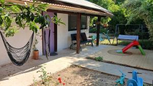 a patio with a hammock and a swing at Little Hula in Yesod Hamaala