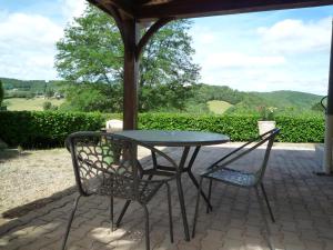 a table and two chairs sitting under a gazebo at Maison du Pech in Carlux