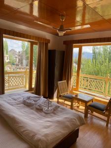 a bedroom with a bed and a balcony at Hinjuma guest house in Leh
