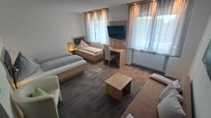 a living room with a couch and a table at Pension Karin in Breitengüßbach