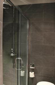 a shower with a glass door and a toilet in a bathroom at The Penny Farthing Hotel in Berkhamsted +34 photos