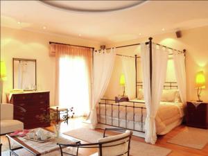 una camera da letto con letto a baldacchino e finestra di Villa in Corfu with Pool and Panoramic Views a Gouviá