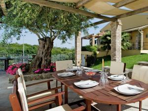 un tavolo e sedie in legno su un patio con un albero di Villa in Corfu with Pool and Panoramic Views a Gouviá Altre 28 foto