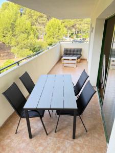 a wooden table and chairs on a balcony at Cap Salou Binda Mar Apartment in Salou