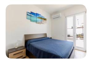 a bedroom with a blue bed and a window at Incanto patio house in Sestu