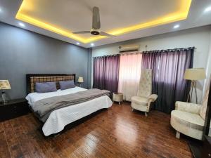 a bedroom with a bed and a couch and a chair at Serene Comfort Suites in Rawalpindi