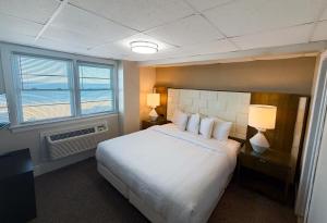 a hotel room with a bed and two windows at Majestic Hotel & Apartments in Ocean City +146 photos