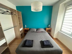 a bedroom with a bed with a blue wall at Maison avec jardin in Crozon