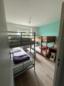 a room with three bunk beds and a desk at Maison avec jardin in Crozon