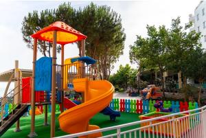 a playground with a slide in a park at Rana E Hedhun Llugani Apartments in Lezhë