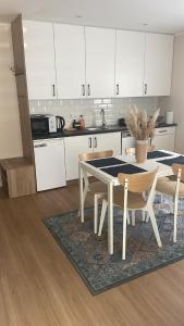 a kitchen with white cabinets and a table and chairs at Le Rond Point in Sieraków