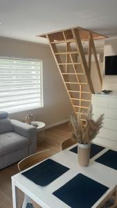a living room with a staircase and a table at Le Rond Point in Sieraków
