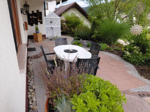 a patio with a table and chairs in a garden at Ferienwohnung Himmelsbach in Schuttertal