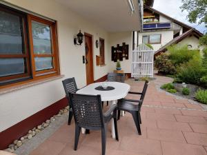 a patio with a white table and chairs at Ferienwohnung Himmelsbach in Schuttertal