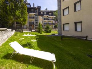 a lawn with a white bench and a table and a building at Studio Tigli-2 by Interhome in Madesimo