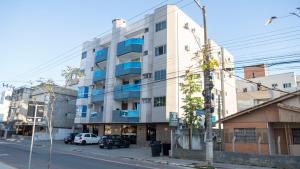 a building with blue windows on a city street at Monte Libano Apart Hotel in Florianópolis